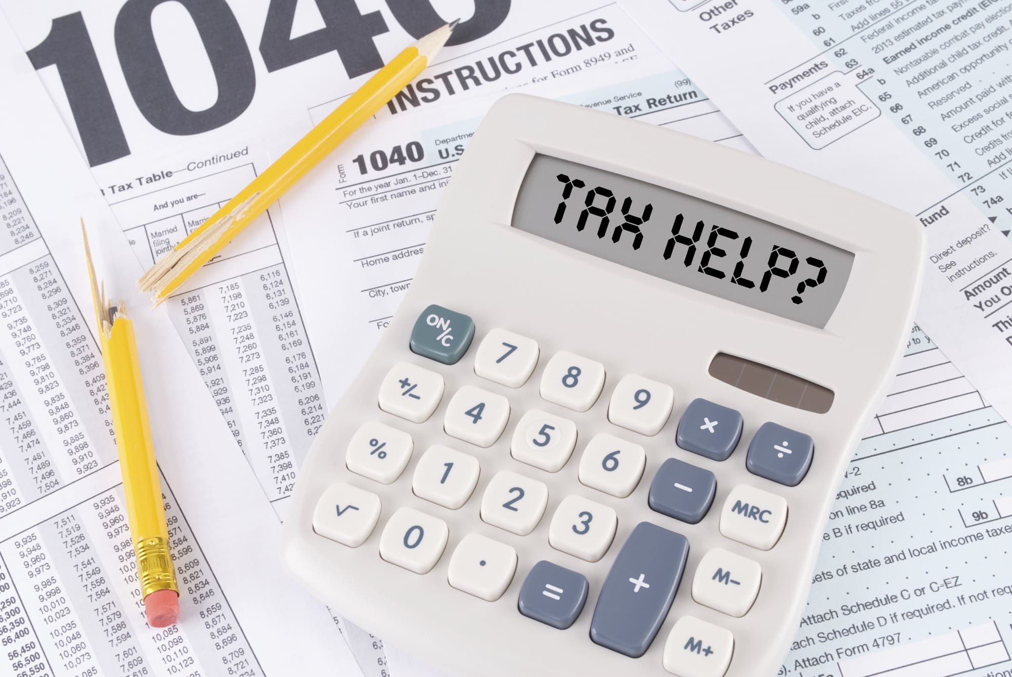 Tax Forms and Broken Pencil with a Calculator that spells out TAX HELP?